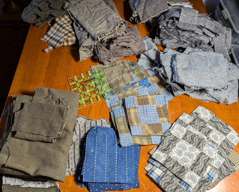 quilt top cut apart, in piles with woolen scraps